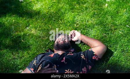 Lächelnder Mann, der auf Gras liegt Stockfoto