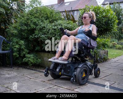 Frau im elektrischen Rollstuhl draußen Stockfoto