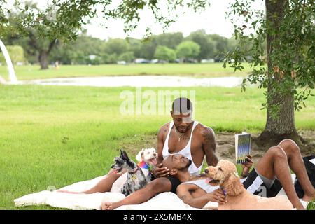 USA, Louisiana, Schwulenpaar mit Hunden, die sich auf dem Rasen im Park entspannen Stockfoto