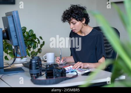 Junge Grafikerin, die im Büro arbeitet Stockfoto