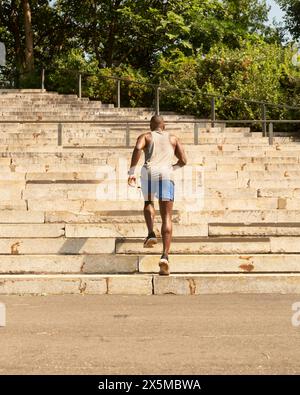Rückansicht eines Sportmannes, der Treppenstufen hochläuft Stockfoto