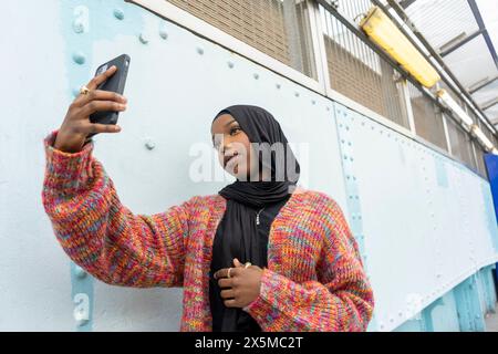 Eine junge Frau im Hijab, die Selfie nimmt Stockfoto