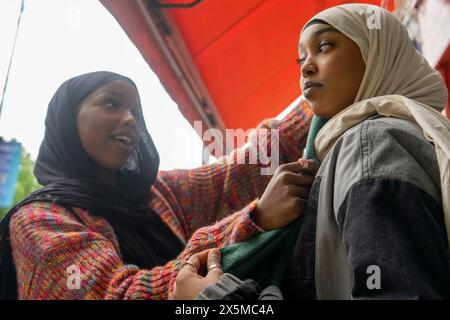 Junge Frau, die Freunde Hijab anpasst Stockfoto