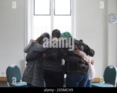 Leute, die sich in der Gruppentherapie umarmen Stockfoto