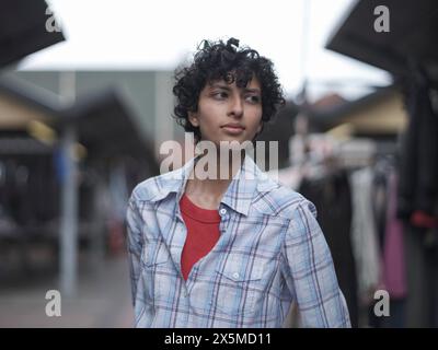 Lächelnde Frau, die auf dem Straßenmarkt steht Stockfoto