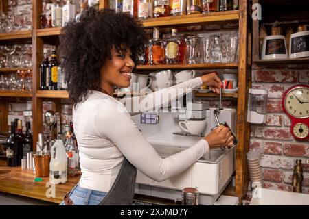 Großbritannien, London, lächelnder Kaffeehausbesitzer, der Kaffee zubereitet Stockfoto