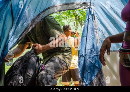 Junger Mann, der das Zelt betritt Stockfoto