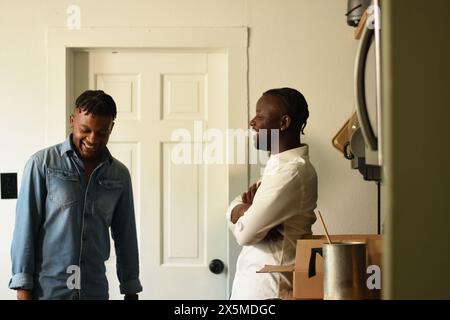 USA, Louisiana, lächelndes schwules Paar, das zu Hause spricht Stockfoto