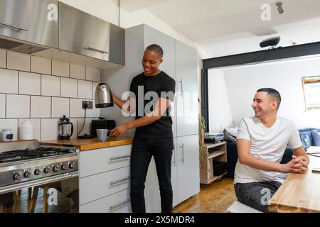 Großbritannien, London, lächelndes schwules Paar in der Küche Stockfoto