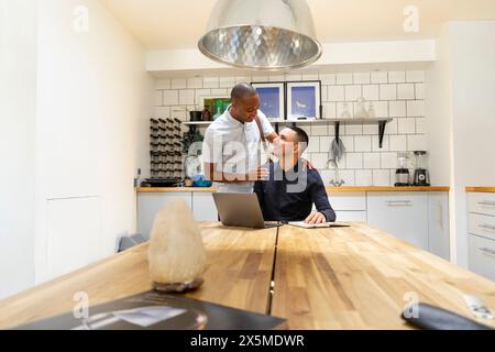 Großbritannien, London, lächelndes schwules Paar in der Küche Stockfoto