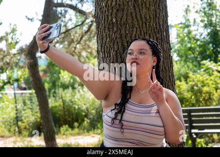 Eine junge Frau, die Selfie im Park macht Stockfoto