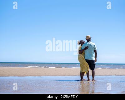 Älteres paar stehen am Strand Stockfoto