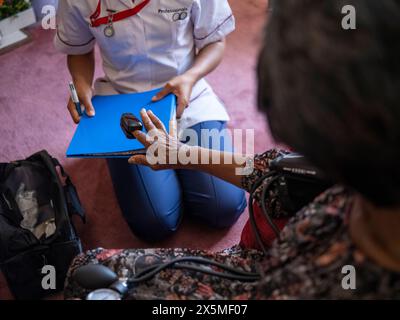 Schwester kümmert sich um ältere Frauen, misst die Sauerstoffsättigung Stockfoto