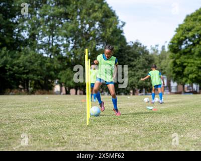 Kinder (8–9) in Uniformen, die auf dem Fußballfeld trainieren Stockfoto