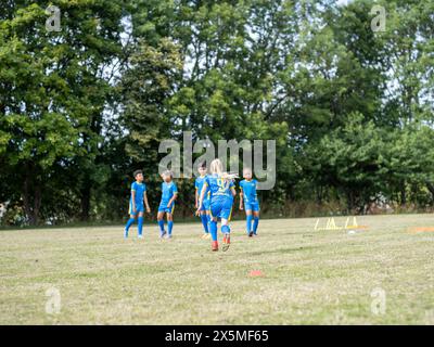 Kinder (8–9) in Uniformen, die auf dem Fußballfeld trainieren Stockfoto