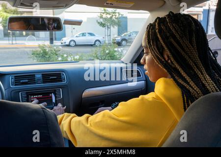 Frau sitzt im Auto auf einer Autofahrt Stockfoto