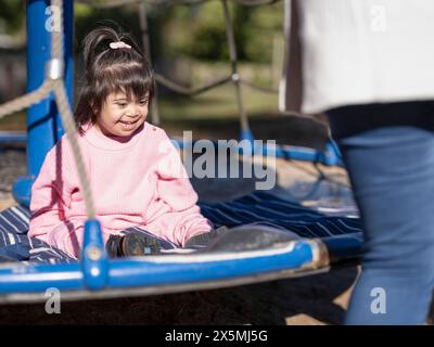 Lächelndes Mädchen mit Down-Syndrom auf dem Spielplatz Stockfoto