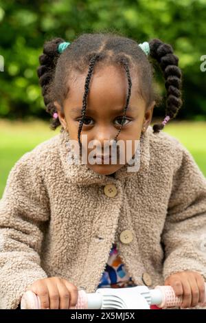 Porträt eines Mädchens mit beigem Mantel im Park Stockfoto