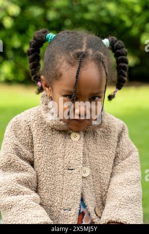 Porträt eines Mädchens mit beigem Mantel im Park Stockfoto