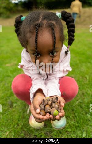 Porträt eines lächelnden Mädchens mit Eicheln im Park im Herbst Stockfoto