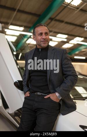 Reifer Mann, der sich gegen ein Luxusauto lehnt Stockfoto