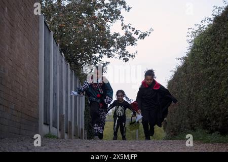 Kinder in Halloween-Kostümen laufen auf dem Fußweg Stockfoto