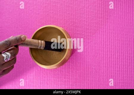 Nahaufnahme der Hand der Frau mit einer Klangschale im Yoga-Studio Stockfoto