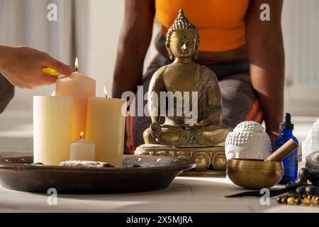 Nahaufnahme einer Frau, die Kerzen im Yoga-Studio zündet Stockfoto