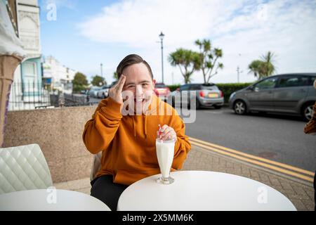 Mann trinkt Milchshake im Straßencafé, Porträt Stockfoto