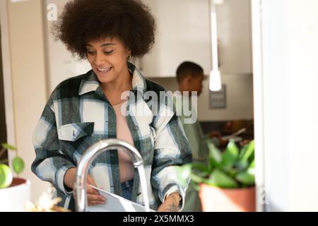 Mutter und Sohn waschen Geschirr und kochen in der Küche Stockfoto