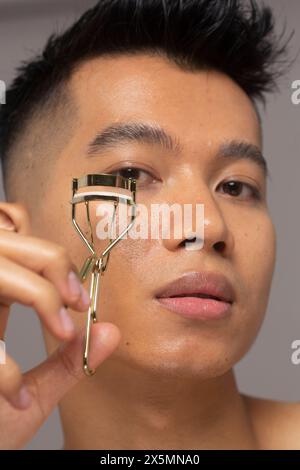 Nahaufnahme einer Person, die Wimpern mit Lockenstab lockert Stockfoto