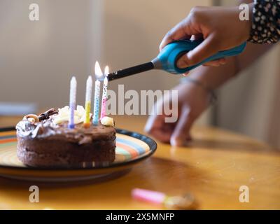 Mädchen Anzünden von Kerzen auf der Geburtstagstorte Stockfoto