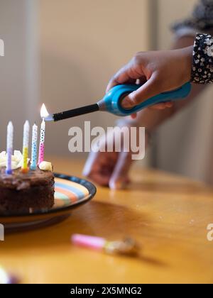 Mädchen Anzünden von Kerzen auf der Geburtstagstorte Stockfoto