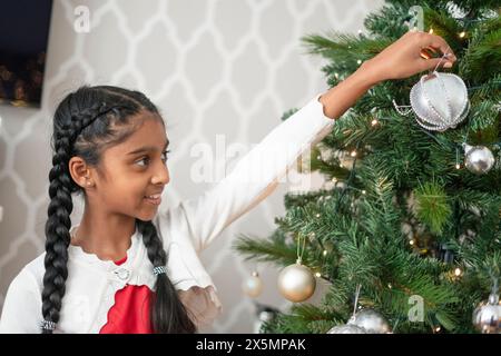 Lächelndes Mädchen schmücken Weihnachtsbaum Stockfoto