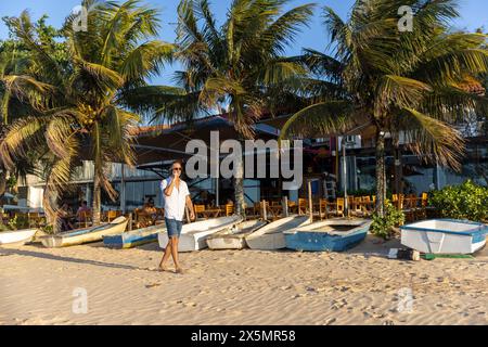 Mann, der am Strand entlang läuft und telefoniert Stockfoto