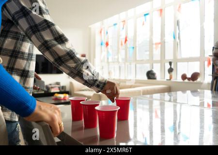 Nahaufnahme von Freunden, die Bier-Pong auf dem Tisch auf der Heimparty spielen Stockfoto