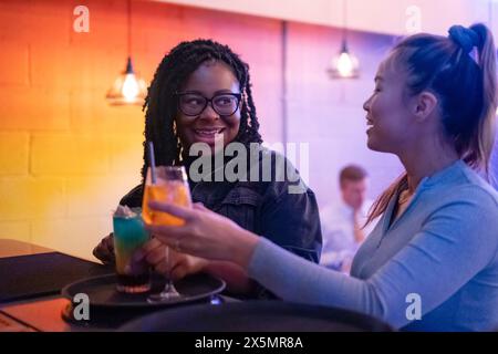 Weibliche Freunde trinken Cocktails an der Bar Stockfoto