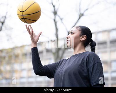 Teenager-Mädchen wirft Basketball in die Luft Stockfoto