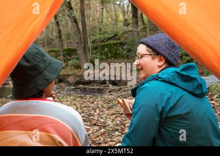 Weibliche Freunde, die im Wald campen Stockfoto