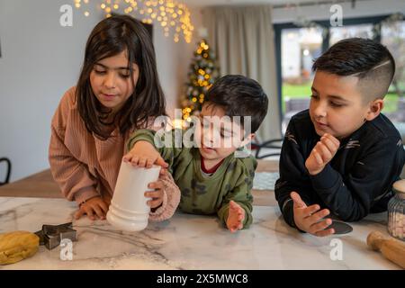 Kinder bereiten Weihnachtskekse in der Küche vor Stockfoto