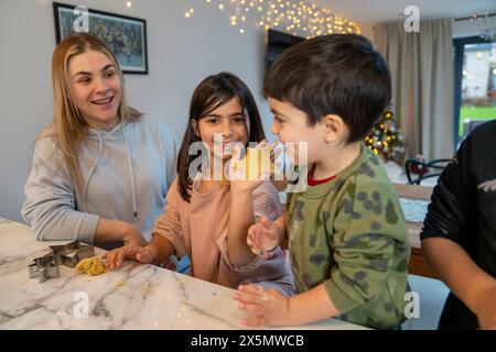 Mom mit Kindern bereitet Weihnachtskekse in der Küche vor Stockfoto