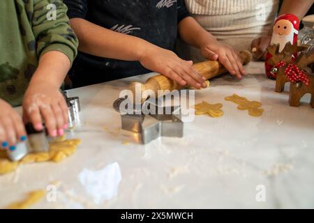 Mom mit Kindern bereitet Weihnachtskekse in der Küche vor Stockfoto