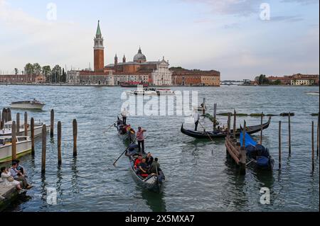 29.04.2024 im Foto: Mehrere Gondeln mit Touristen und Gondolieren fahren über einen Kanal in Venedig, im Hintergrund die San Giorgio Maggiore-Kirche, Abbazia di San Giorgio Maggiore Venedig Venetien Italien *** 29 04 2024 auf dem Foto überqueren mehrere Gondeln mit Touristen und Gondoliern einen Kanal in Venedig, im Hintergrund die Kirche San Giorgio Maggiore, Abbazia di San Giorgio Maggiore Venedig Veneto Italien Copyright: xEHLxMedia/Erik-HolmxLanghofx 240429 venedig-2 36 Stockfoto