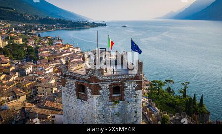 Blick aus der Vogelperspektive auf das Schloss Scaliger in Malcesine am Gardasee, historische Architektur vor pulsierender Stadt und blauem Wasser Stockfoto