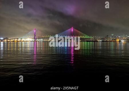 Die Gwangan Bridge oder Diamond Bridge bei Nacht von Gwangalli Beach, Busan, leuchtende Wolken, Regenbogenfarben, Südkorea Stockfoto