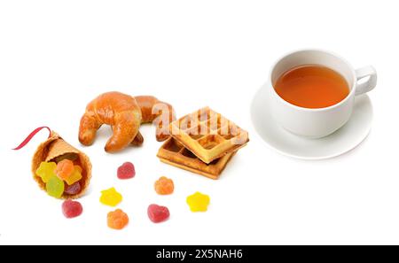 Tasse mit Tee und köstlichem Gebäck auf weißem Hintergrund. Flache Lage, Draufsicht. Stockfoto