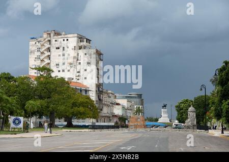 HAVANNA, KUBA - 27. AUGUST 2023: Hässliches Haus auf der Habana Straße in Havanna, Kuba mit Maximo Gomez Monument im Hintergrund Stockfoto