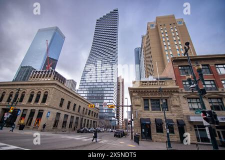 Calgary Alberta Canada, 03. April 2024: Die Innenstadt von der Straße kreuzt sich mit Menschen, die die Straße überqueren und historische Gebäude und Landgüter überblicken Stockfoto