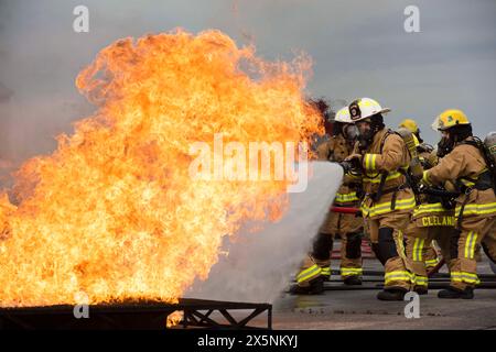 Swanton, Ohio, USA. Mai 2024. Feuerwehrleute, die dem 180th Fighter Wing der Ohio National Guard zugeteilt sind, arbeiten zusammen, um ein Feuer während einer Live-Brandübung in Swanton, Ohio, am 6. Mai 2023 zu löschen. Während der Übung löschten die Feuerwehrleute Brände aus, die verschiedene Umstände simulieren, unter denen ein Brand in realen Szenarien ausbrechen könnte. (Kreditbild: © Camren Ray/U.S. National Guard/ZUMA Press Wire) NUR REDAKTIONELLE VERWENDUNG! Nicht für kommerzielle ZWECKE! Stockfoto