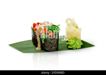 Leichtes Gunkan Maki Sushi mit Hiyashi Wakam, Paprika, Nusssauce und Sesam serviert auf Bambusblatt mit würzigem Wasabi und eingelegtem Ingwer, isoliert darauf Stockfoto